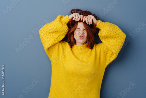 Frustrated angry young woman tearing at her hair