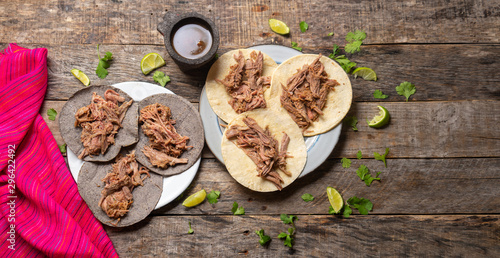 Mexican slow cooked lamb tacos also called barbacoa on wooden background