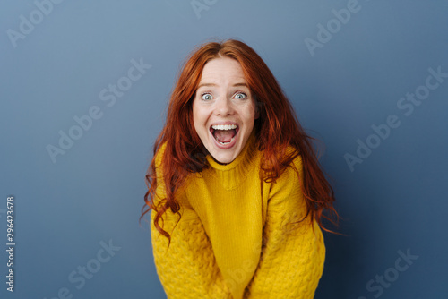 Laughing delighted young woman leaning forwards