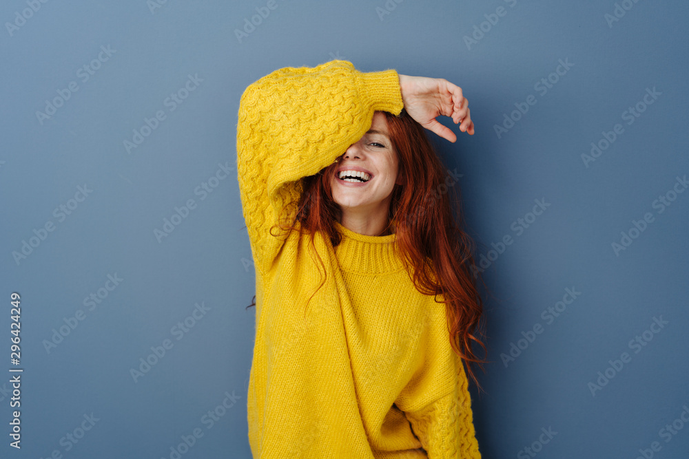 Laughing playful young woman covering an eye - obrazy, fototapety, plakaty 