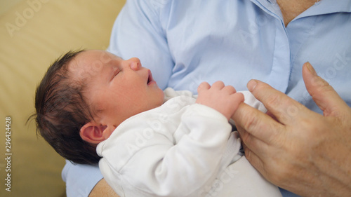 Portrait of newborn baby child yawn in safety parent arms