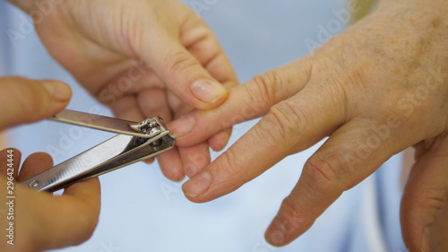 Elderly home care, hand cutting nails of old woman