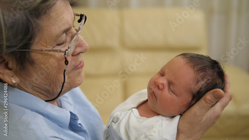 Portrait of old grandmother and young newborn baby, past and future together
