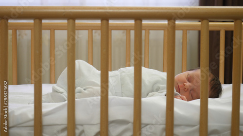 Newborn child sleeping in a baby crib, peaceful dreams
