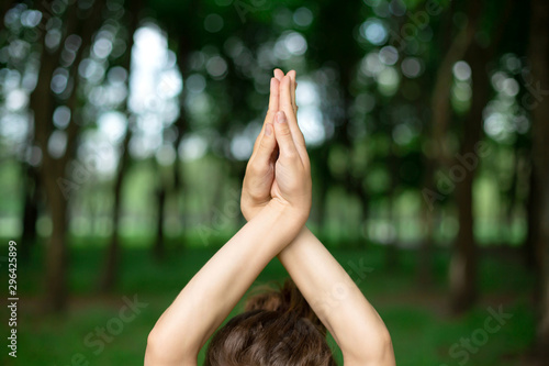 A young sports girl practices yoga in a quit green summer forest, yoga assans posture. Meditation and unity with nature photo