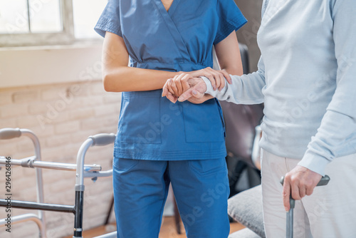 Canvastavla Cropped of female social worker helping senior woman to walk with walker at home