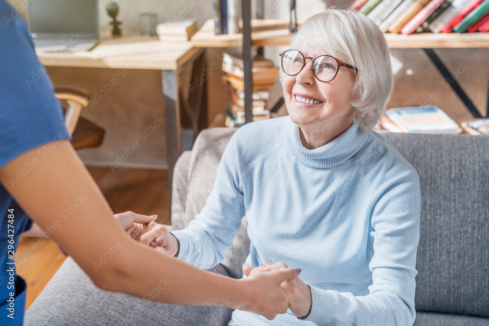 Cropped image of female professional caregiver taking care of elderly woman at home Cropped image of female professional caregiver taking care of elderly woman at home