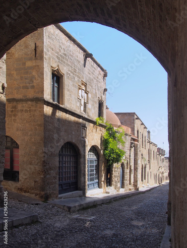 view of the street of the knights of rhodes lined with medieval buildings viewed through an archway