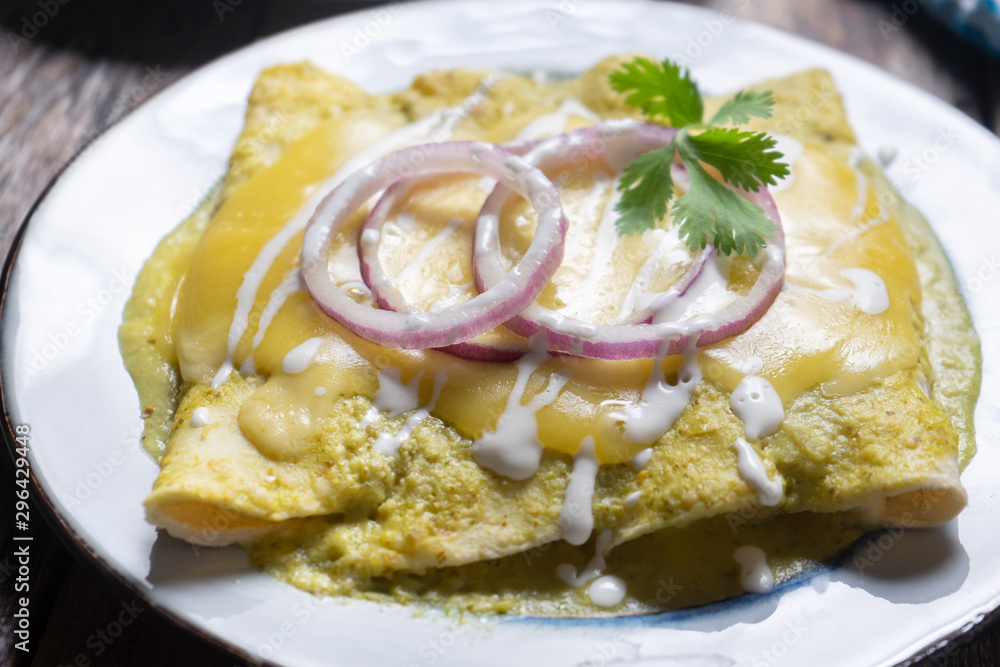 Mexican green enchiladas with melted cheese also called 