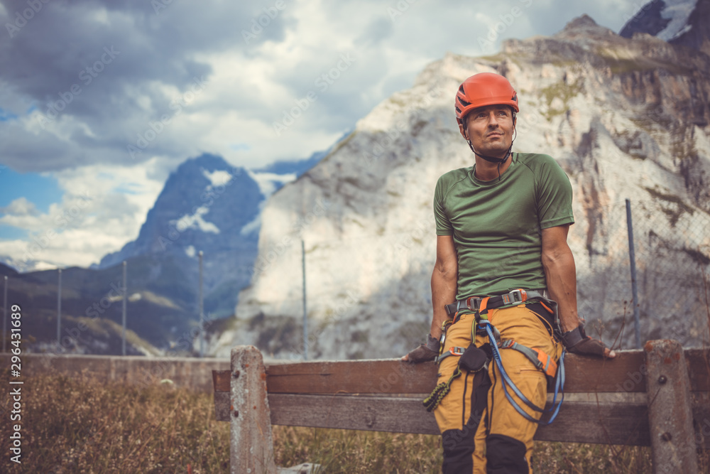 Naklejka premium Young man climbing on a rock in Swiss Alps - via ferrata/klettersteig
