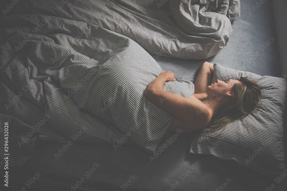 Pretty, middle-aged woman sleeping in her bed at home, having a good night rest in a comfortable bed - obrazy, fototapety, plakaty 
