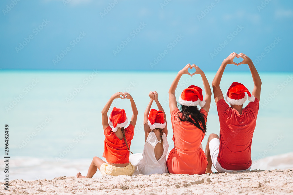Happy family with two kids in Santa Hat on summer vacation