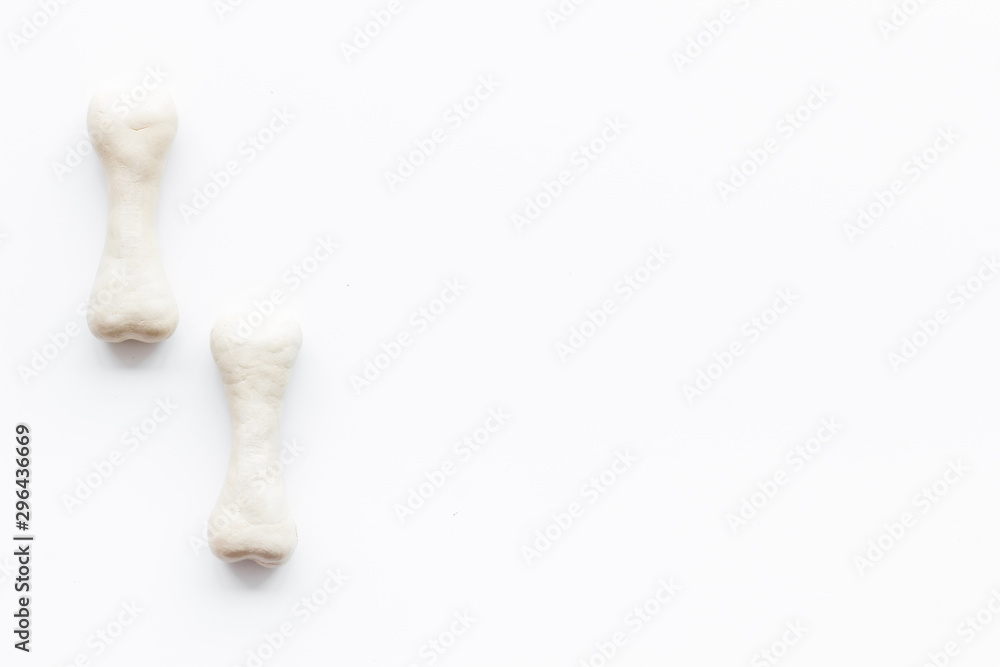 Food and toys for dogs. Chewing bones on white background top view copy space