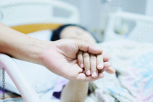 Close up focus on the Shake hands of a patient sick encourage encouragement on the bed in hospital ward.