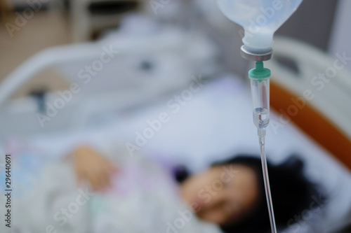 Woman sleep on bed and she is on a drip receiving a saline solution