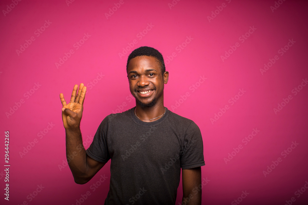 african man over pink wall happy and counting four with fingers african man over pink wall happy and counting four with fingers