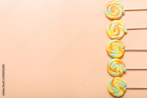 Colorful lollipop in row on color background. Flat lay.