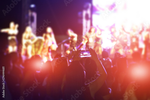 Fototapeta Naklejka Na Ścianę i Meble -  Women using smartphone take a photo in concert,Happy new year party