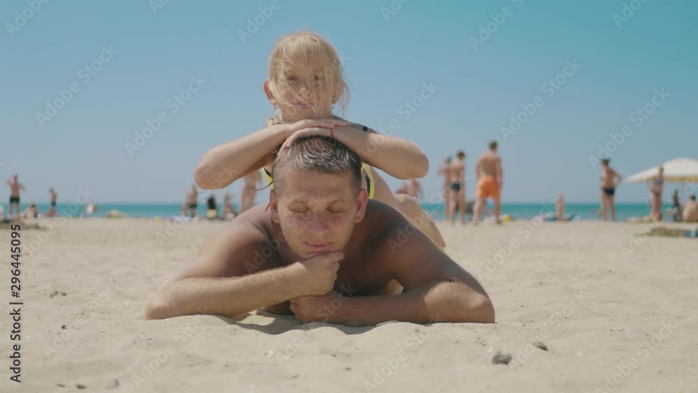 Happy father and daughter play on the beach on sea. Concept of friendly family, travel, lifestyle. Happy father and daughter play on the beach on sea. Concept of friendly family, travel, lifestyle.