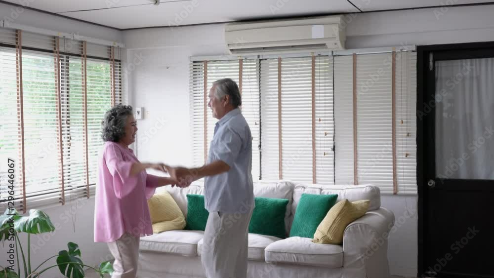 Happy asian mature senior couple dancing laughing in living room at home. Beautiful romantic middle aged older grandparents relaxing fun together celebrating anniversary enjoy care love tenderness. Happy asian mature senior couple dancing laughing in living room at home. Beautiful romantic middle aged older grandparents relaxing fun together celebrating anniversary enjoy care love tenderness.