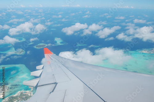 A plane amidst the clouds and coral islands of the Maldives