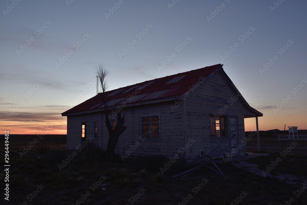casa de madera solitaria con luz de atardecer filtrando por las ventanas casa de madera solitaria con luz de atardecer filtrando por las ventanas