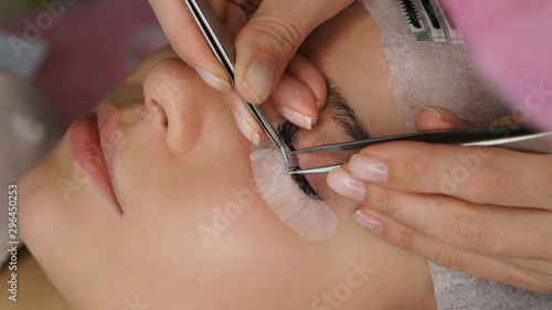 Beautiful Woman with long eyelashes in a beauty salon. Eyelash extension procedure.