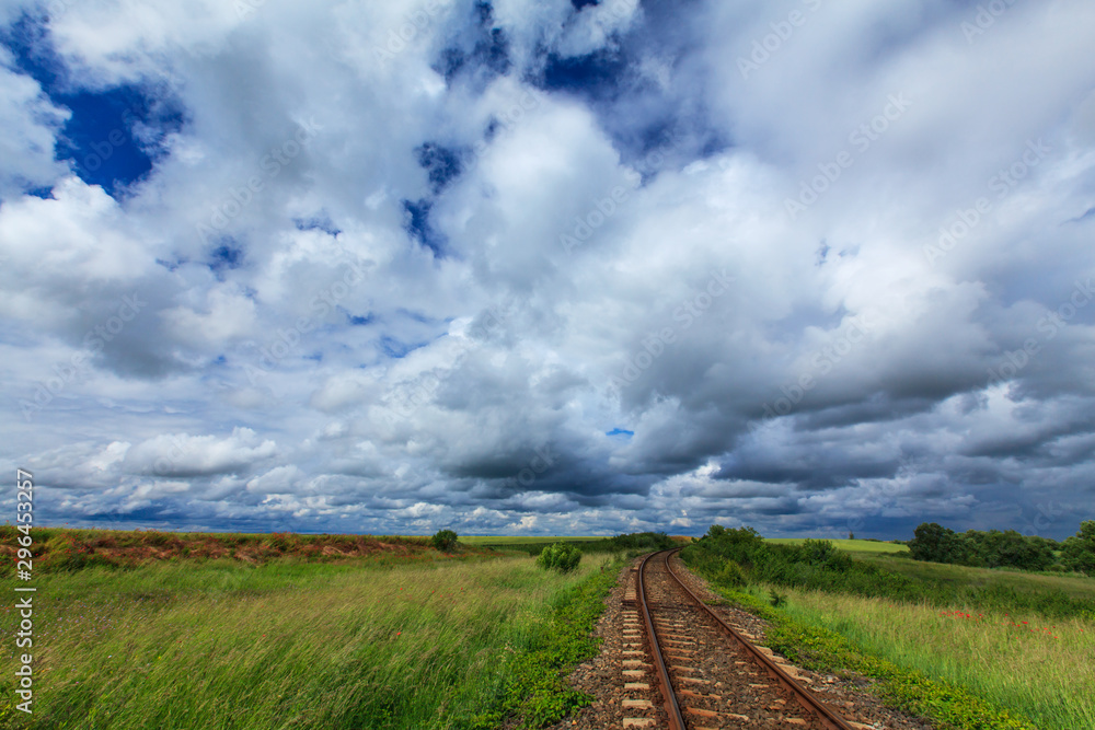 Old railroad in remoter rural area in Europe on a summer day, under a sky covered with storm clouds Old railroad in remoter rural area in Europe on a summer day, under a sky covered with storm clouds