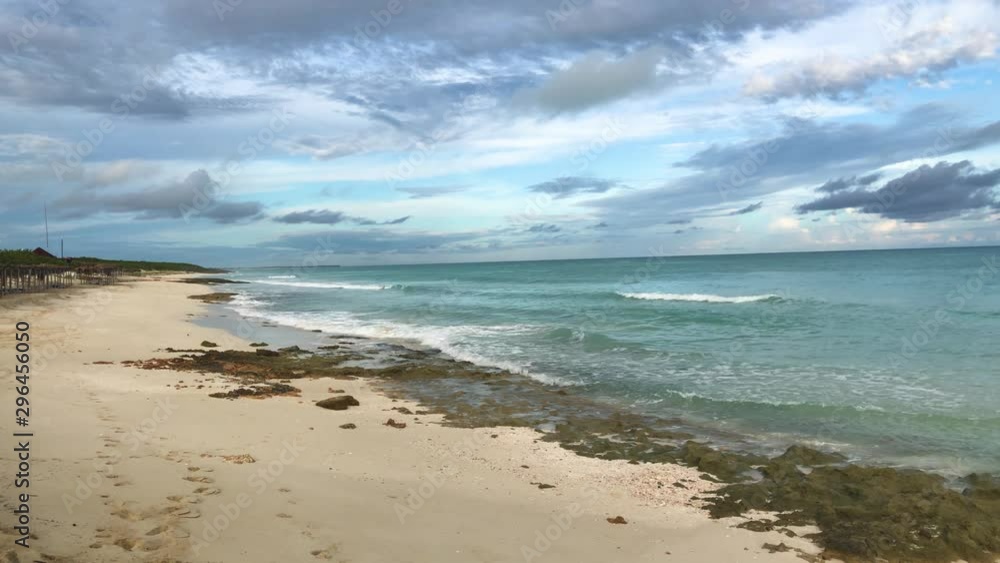 Camera pan along rocky beach with cloud formations Camera pan along rocky beach with cloud formations