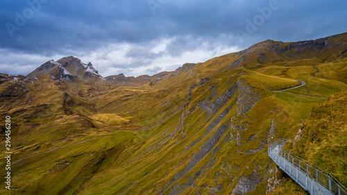 Landscape view of First mountain and First Cliff Walk in cloudy day. Alpine scenery with orange meadow at First(Grindelwald) the popular tourist attraction Swiss alps, Grindelwald, Switzerland