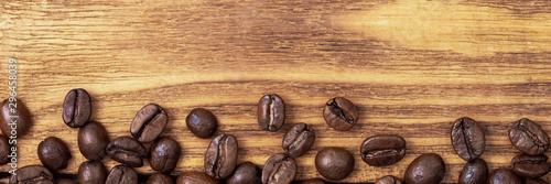 Coffee bean. The background of roasted coffee beans is brown on wooden boards. layout. Flat lay.
