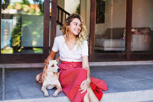 Photography Beautiful caucasian woman hugging her mongrel dog pet in front of her house