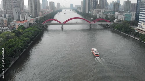 A large metropolis with developed infrastructure. In the cade, a yacht floats along the river that goes into the distance. A large number of bridges connecting two banks. Guangzhou, China photo