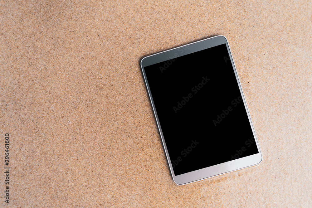 Fototapeta premium Smart phone on sand beach texture background.