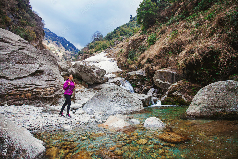 Beautiful woman trekking alone in Indian Himalayas. Full length wide angle shot