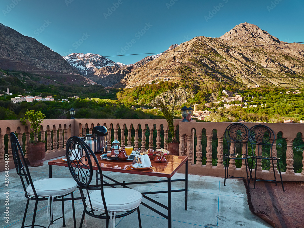 Traditional moroccan breakfast setting with mountain view, table and chairs