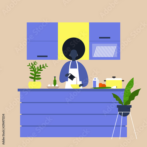 Young black female chief cooking food at the kitchen island table