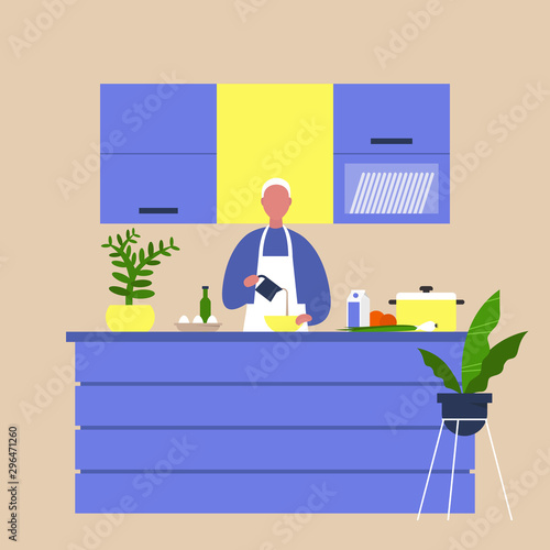 Young male chief cooking food at the kitchen island table