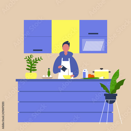 Young male chief cooking food at the kitchen island table