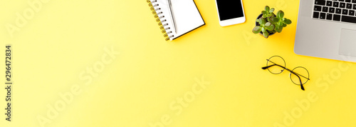 Office desktop with accessories on yellow table. Business background. Banner