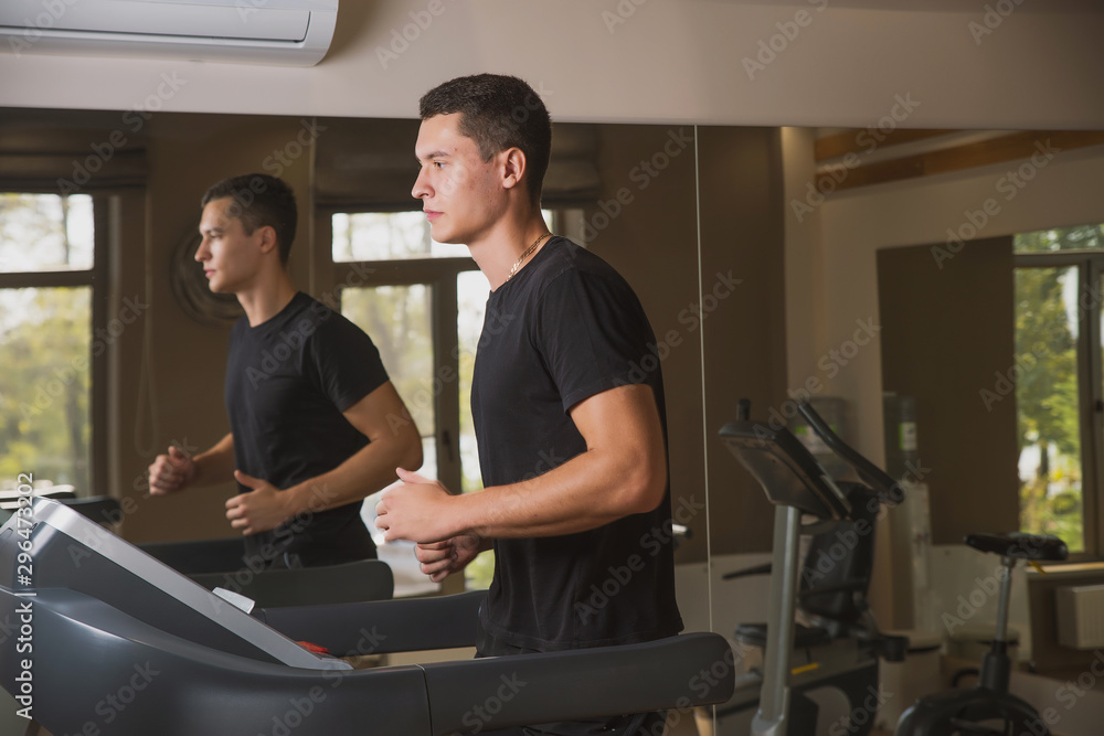 Athlete engaged in the gym, a Young man doing cardio on the treadmill Athlete engaged in the gym, a Young man doing cardio on the treadmill