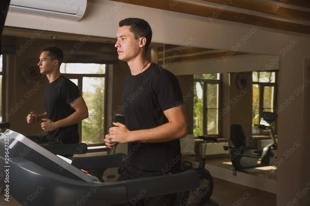 Athlete engaged in the gym, a Young man doing cardio on the treadmill