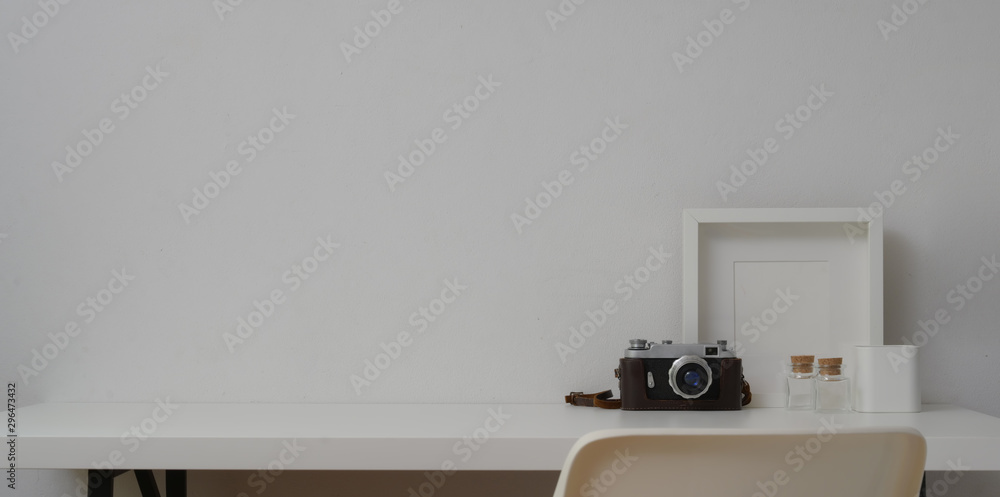 Minimal workspace with mock up frames and camera in white wall background