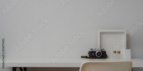 Minimal workspace with mock up frames and camera in white wall background © bongkarn
