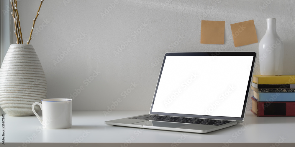 Minimal workspace with open blank screen laptop computer and coffee cup Minimal workspace with open blank screen laptop computer and coffee cup