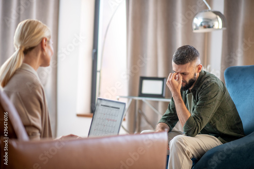 Dark-haired man feeling concerned while visiting psychoanalyst