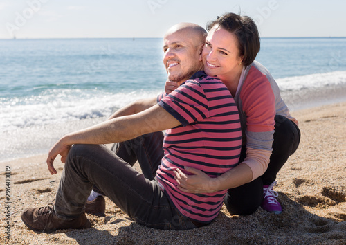 mature man and female sitting near sea at sunny day © caftor