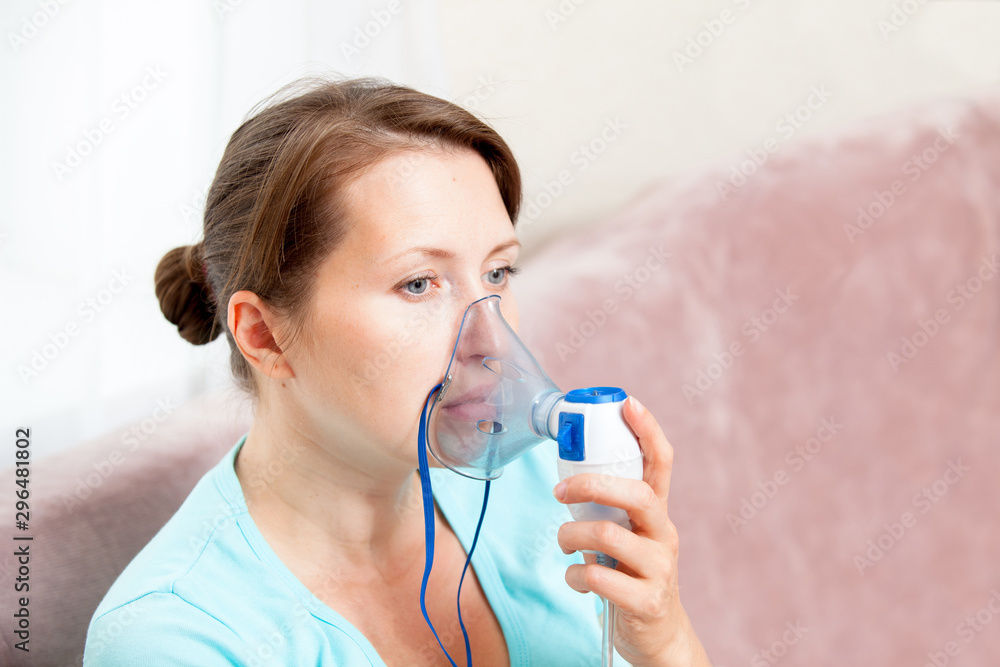 Young woman doing inhalation with a nebulizer at home Young woman doing inhalation with a nebulizer at home