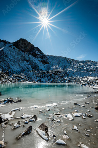 Türkisfarbener See auf der Macun Seenplatte im ersten Schnee im Herbst photo