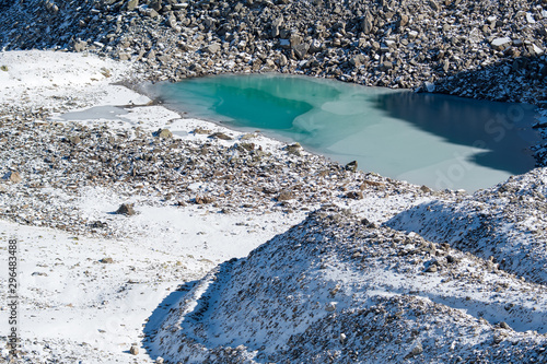 Türkisfarbener See auf der Macun Seenplatte im ersten Schnee im Herbst photo